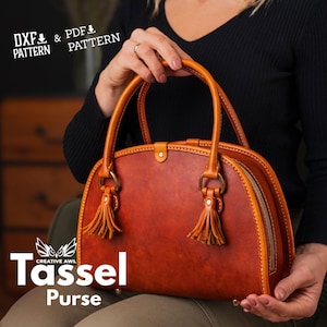 May include: A brown leather purse with a rounded shape and two tassels. The purse has a zipper closure and a top handle. The text "Tassel Purse" is visible on the bottom of the image.