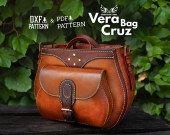 May include: A brown leather Vera Bag Cruz with a flap closure and a buckle. The bag has a front pocket and a top handle. The bag is sitting on a wooden surface.