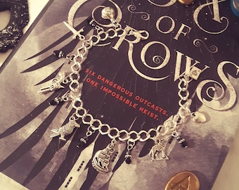 Pulsera con dije metálico inspirada en Seis de Cuervos