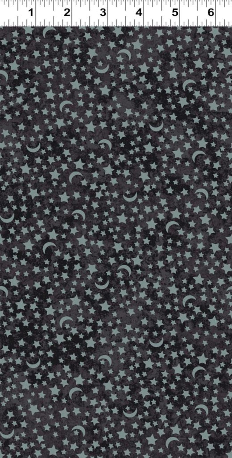 Puede incluir: Una tela gris oscura con un patr&oacute;n repetitivo de estrellas y lunas crecientes de color azul claro.