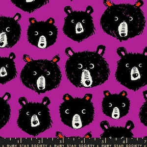May include: A purple fabric with a repeating pattern of black bear faces. The bears have white eyes and noses.