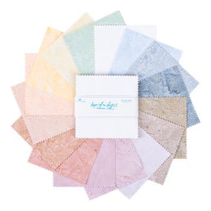 May include: A collection of fabric squares in a variety of pastel colors, arranged in a circular pattern. The squares have a textured appearance and are fanned out around a stack of white squares with the text "hand-dyed" and "cotton fabric".