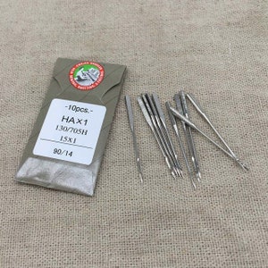 May include: A pack of 10 silver sewing machine needles, labeled "HAX1 130/705H 15X1 90/14 -10pcs.-".