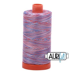 May include: A spool of Aurifil thread in red, white, and blue. The thread is tightly wound around a cylindrical core with a red base and top. The Aurifil logo is visible on the side.