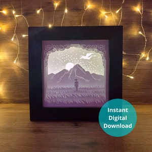 May include: A black framed paper cut-out art piece with a purple mountain scene, a white bird flying, and a person standing in a field of grass. The background is a starry night sky with a white moon. The text "Instant Digital Download" is in the lower right corner.