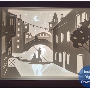 Peut inclure: Une silhouette noire et blanche d'une gondole avec un gondolière ramant sur un canal à Venise, en Italie. La scène se déroule la nuit avec une lune croissante et des étoiles dans le ciel. Des bâtiments bordent le canal avec des fenêtres et des balcons. Le texte "Téléchargement numérique instantané" est dans le coin inférieur droit.