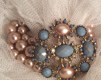Statement bracelet. floral design teal cut stones, crystals add bling.