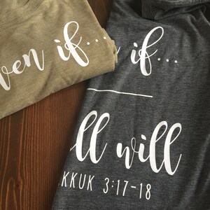 May include: Two t-shirts with the phrase "Even if... all will" printed on them. The top shirt is a light brown color and the bottom shirt is a dark gray color. The text is in white and the bottom shirt also has the text "KKUK 3:17-18" printed on it.