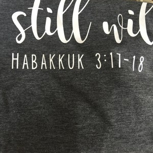 May include: Gray and green t-shirt with the text "still will" and "HABAKKUK 3:17-18" in white.