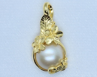 May include: Gold-tone pendant featuring a large, lustrous, off-white pearl. The pendant is adorned with floral and leaf accents. The pearl is approximately 0.75 inches in diameter. The bail is integrated into the floral design.