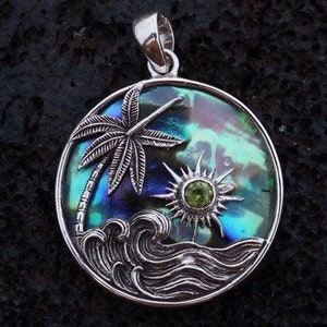 May include: A silver pendant featuring a palm tree, sun, and waves, all set against a blue, green, and purple abalone shell background. The sun has a green gemstone in the center.