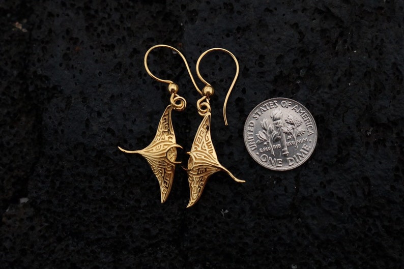 May include: Gold-tone earrings shaped like manta rays, shown next to a US dime for scale.