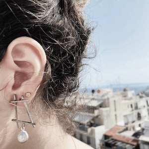 Pendientes largos de plata abstractos y geométricos con perlas.
