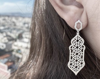 Puede incluir: Pendientes de plata con un diseño geométrico intrincado. Los pendientes tienen forma de linterna con un pequeño octógono en la parte superior.