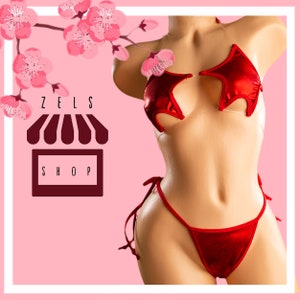 May include: Red satin lingerie set with a star-shaped top and a high-cut bottom. The set is on a model with a pink background.