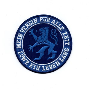 Op de afbeelding: Blauw en wit geborduurde patch met een leeuw en de tekst "Mein Verein fur alle Zeit lang - Lowe ein Leben lang".