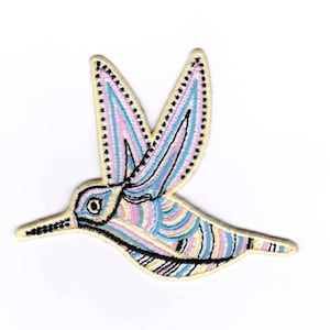 Könnte beinhalten: Ein bunter gestickter Aufnäher mit einem Kolibri in Rosa, Blau und Gelb. Der Kolibri fliegt mit ausgebreiteten Flügeln.