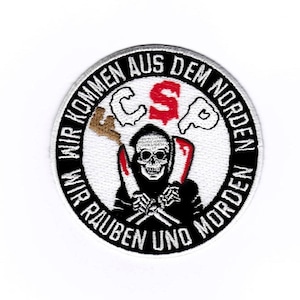 May include: A black and white embroidered patch with a skull and crossbones in the center. The text around the skull reads "Wir kommen aus dem Norden Wir rauben und morden" in white lettering.