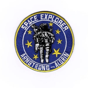 May include: A blue and yellow embroidered patch with a space explorer in a spacesuit. The text reads "Space Explorer Armstrong - Aldrin".