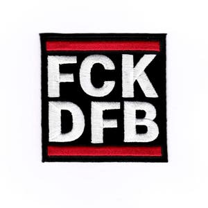 Puede incluir: Parche bordado negro y rojo con el texto "FCK DFB" en blanco.