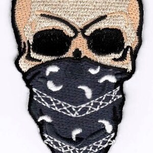 May include: Embroidered patch of a white skull wearing a black bandana with a white paisley pattern.