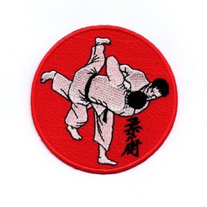 Könnte beinhalten: Ein roter, runder gestickter Aufnäher mit einem weißen Bild von zwei Personen in einem Judo-Wurf. Der Text "柔術" ist in Schwarz unter dem Bild gestickt.