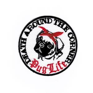 Könnte beinhalten: Schwarzer und weißer gestickter Aufnäher mit einem Mops, der ein rotes Bandana trägt. Der Aufnäher ist rund und hat den Text "Death Around The Corner Pug Life" in einem weißen Kreis mit schwarzem Rand.