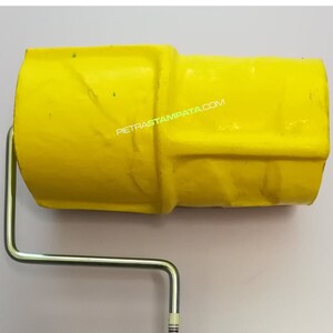 May include: A yellow paint roller with a red handle and a silver metal frame. The roller is designed to create a textured finish on walls or other surfaces. The roller is labeled with the website "PIETRASTAMPATA.COM".