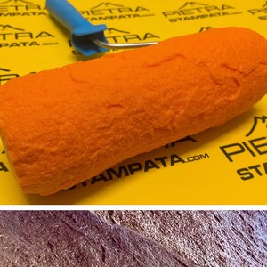 May include: Orange textured paint roller with a blue handle. The roller is used to create a stone-like effect on walls. The roller is on a yellow surface with the text "PIETRA STAMPATA.COM".