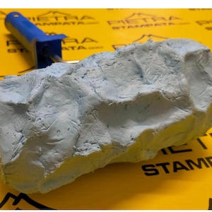 May include: A blue textured paint roller with a blue handle. The roller is designed to create a stone-like effect on walls.