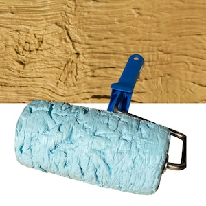 May include: A paint roller with a textured light blue rubber sleeve featuring a wood grain pattern. The roller is attached to a blue plastic handle and a metal frame, shown against a tan surface with a matching wood grain texture.