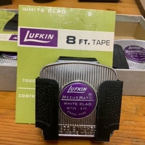 May include: A silver and black Lufkin MezurMatic 8 ft. tape measure with a purple label that reads "White Clad W728 - 8 ft. Press Here".