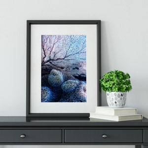 May include: A framed print of a blue and purple underwater scene with coral and a black frame.