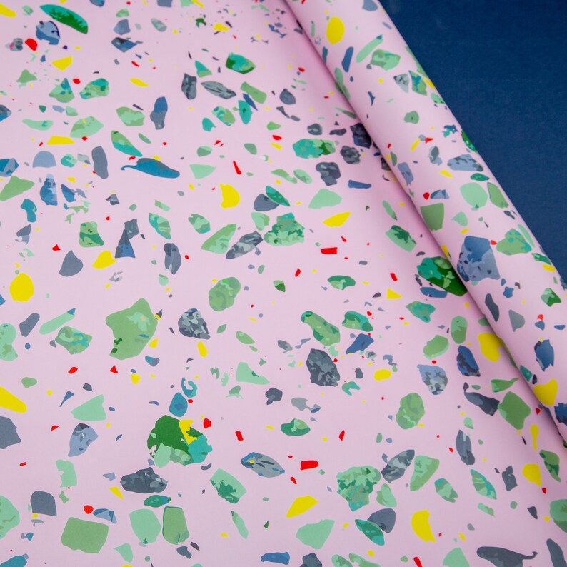 May include: Pink wrapping paper with a terrazzo pattern featuring colorful chips in shades of green, blue, yellow, and red.