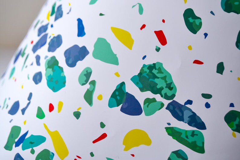 May include: White background with a scattered pattern of blue, green, yellow, and red irregular shapes.