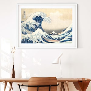 May include: A framed print of a famous Japanese woodblock print depicting a large wave crashing over a boat with Mount Fuji in the background. The print is in shades of blue, white, and gray.