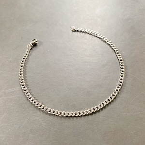 May include: A silver chain bracelet with a lobster clasp.