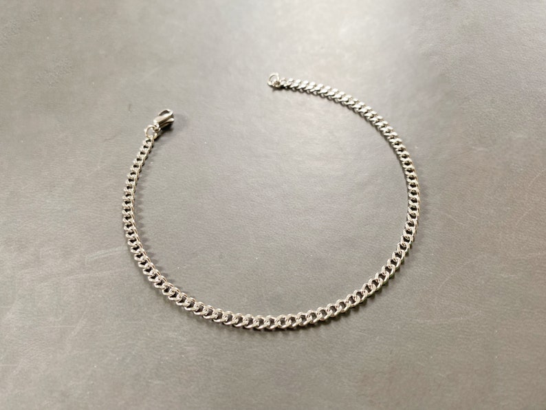 May include: A silver chain bracelet with a lobster clasp.