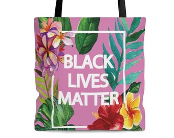 May include: Pink tote bag with a floral design and the text "BLACK LIVES MATTER" in a white rectangle.