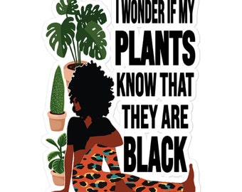 Puede incluir: Una mujer de piel oscura y cabello negro rizado se sienta con las piernas cruzadas sobre una esterilla de yoga de estampado de leopardo. Está rodeada de plantas en macetas. El texto "Me pregunto si mis plantas saben que son negras" está escrito en letras negras sobre un fondo blanco.