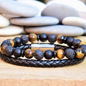 May include: A black leather bracelet with two rows of beads. The beads are black, brown, and gold. The bracelet has a magnetic clasp.