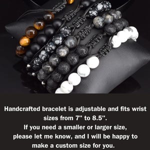 May include: A set of five adjustable bracelets featuring round beads in tiger eye, matte black, snowflake obsidian, grey, and white stone. Each bracelet uses a black cord with a sliding knot closure, fitting wrist sizes from 7 inches to 8.5 inches.