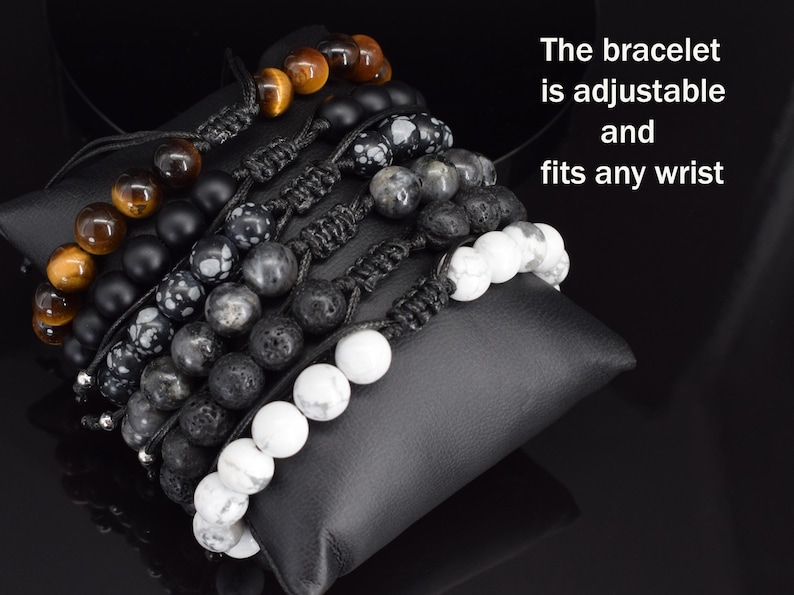 May include: A collection of six adjustable beaded bracelets featuring tiger eye, matte black, snowflake obsidian, grey, lava, and white howlite beads with black cord knots. The text on the image reads: The bracelet is adjustable and fits any wrist.