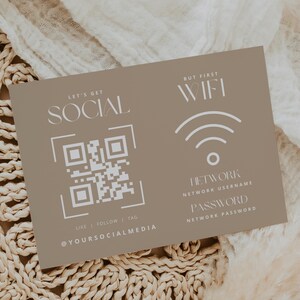 May include: A tan card with white text and graphics. The card reads "LET'S GET SOCIAL" with a QR code and "LIKE | FOLLOW | TAG @YOURSOCIALMEDIA". The other side says "BUT FIRST WIFI" with network details.
