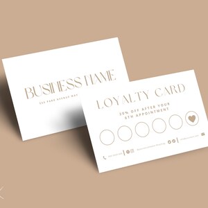 Op de afbeelding: Twee witte visitekaartjes met gouden tekst. E&eacute;n kaart leest "BUSINESS NAME" en "555 PARK AVENUE WAY". De andere kaart is een klantenkaart met de tekst "LOYALTY CARD" en "20% OFF AFTER YOUR 6TH APPOINTMENT."