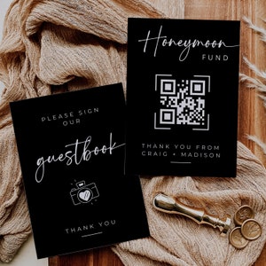 May include: Two black cards with white text. The top card says "Honeymoon Fund" and has a QR code. The bottom card says "Please sign our guestbook" and has a camera icon with a heart.