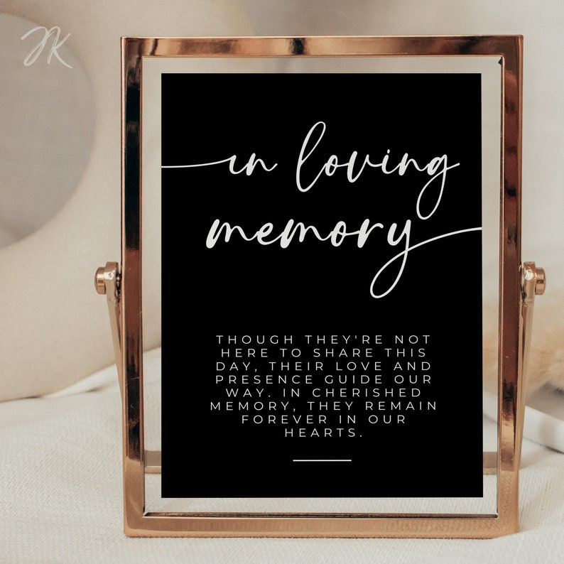 May include: A black framed sign with white text that reads "In loving memory" and a message about remembering loved ones. The sign is on a gold stand.