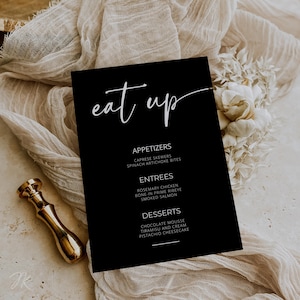May include: Black and white menu card with the text "eat up" in a handwritten font. The menu lists appetizers, entrees, and desserts.