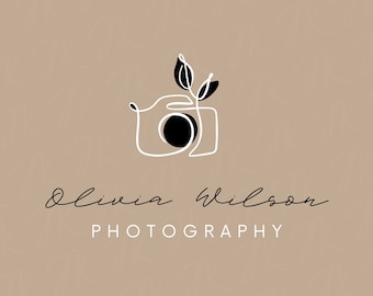 May include: A minimalist logo design featuring a white outline of a camera with a black circle for the lens. Two stylized leaves are drawn above the camera. The text "Olivia Wilson PHOTOGRAPHY" is written below the camera in a cursive font.
