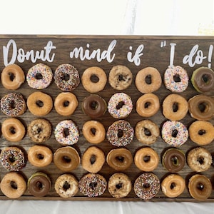 Our Donut walls are sure to be a hit at your next party or event! Each one comes with a stand on the back and has a variety of color choices. It has 30 pegs, and they can be short, that hold 1 donut per peg or long, that hold 2 donuts peg.